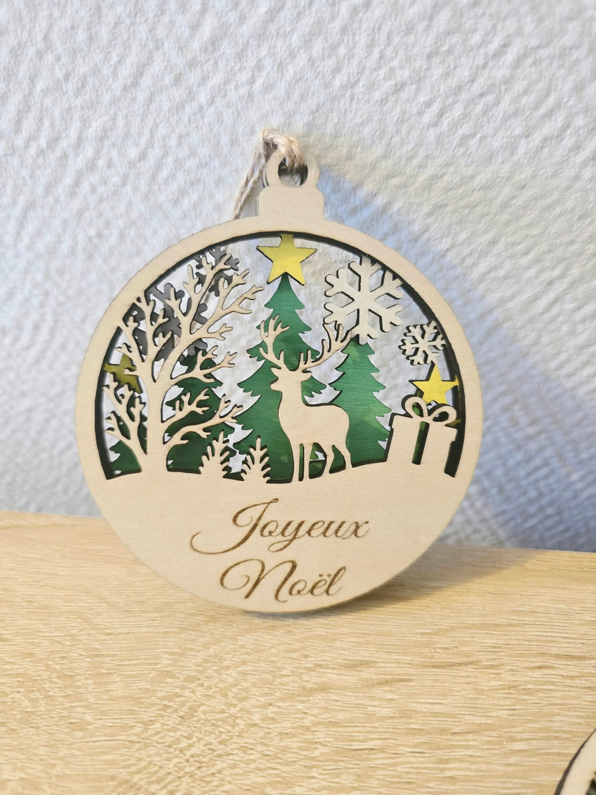 Boule de Noël en bois ajouré avec cerf, sapins et message Joyeux Noël – 9 cm