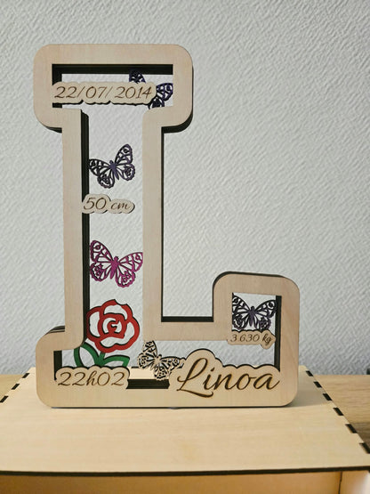 Détail de la lettre de naissance L avec prénom, informations de naissance et papillons
