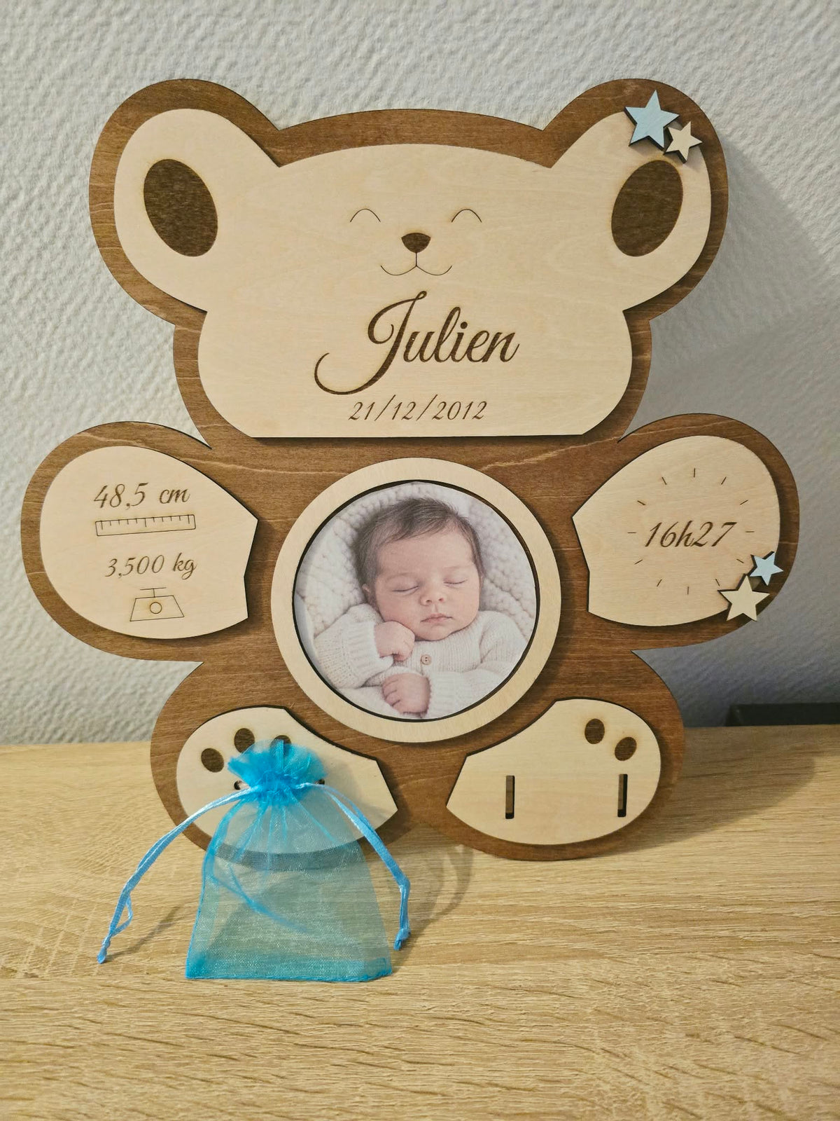 Ourson de naissance personnalisé en bois avec cadre photo rond, informations gravées, étoiles bleues et pochon pour la première mèche de cheveux.